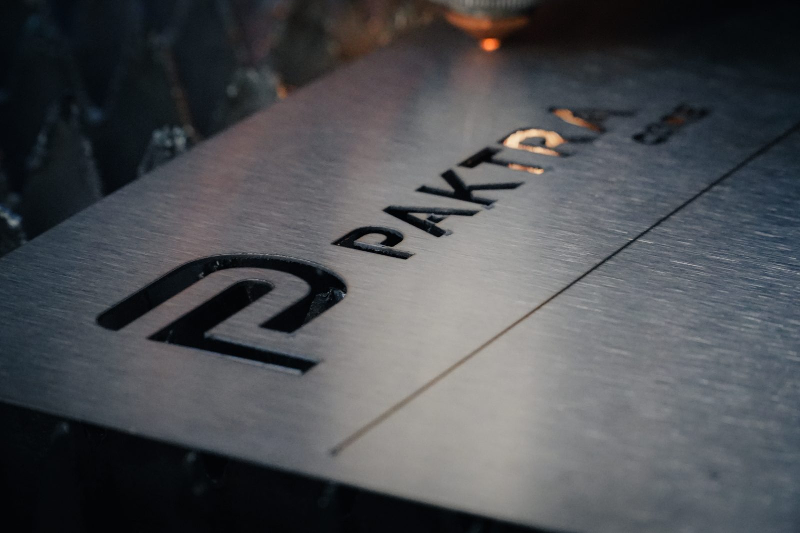 Lámina de acero con el logo PAKTRA recién cortada con láser de fibra en planta